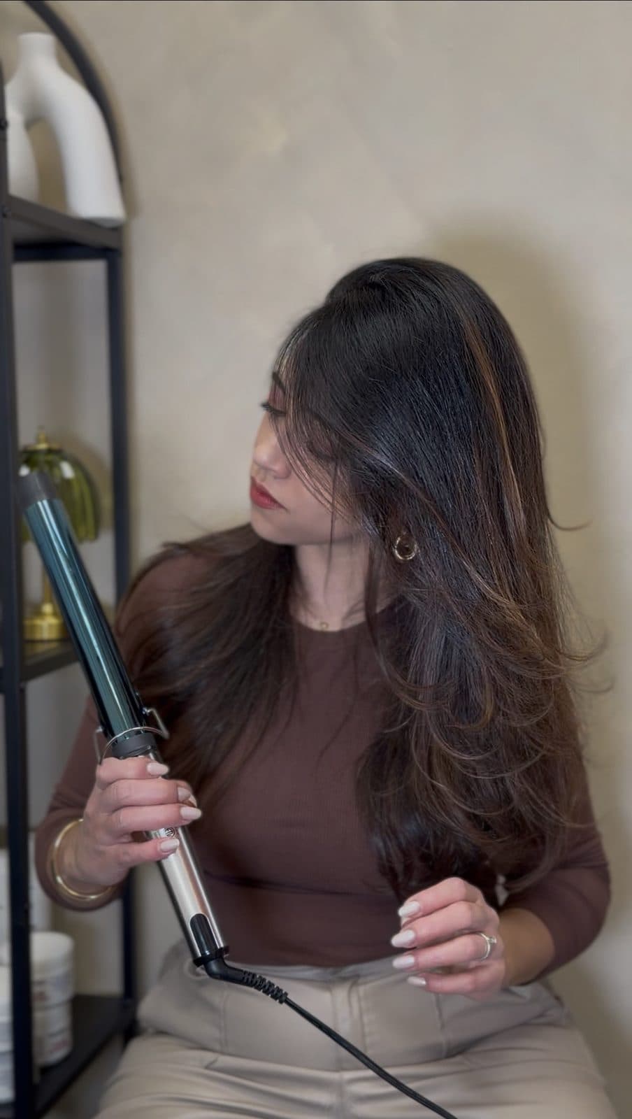 Amanda finalizando um cabelo longo com modelador no salão